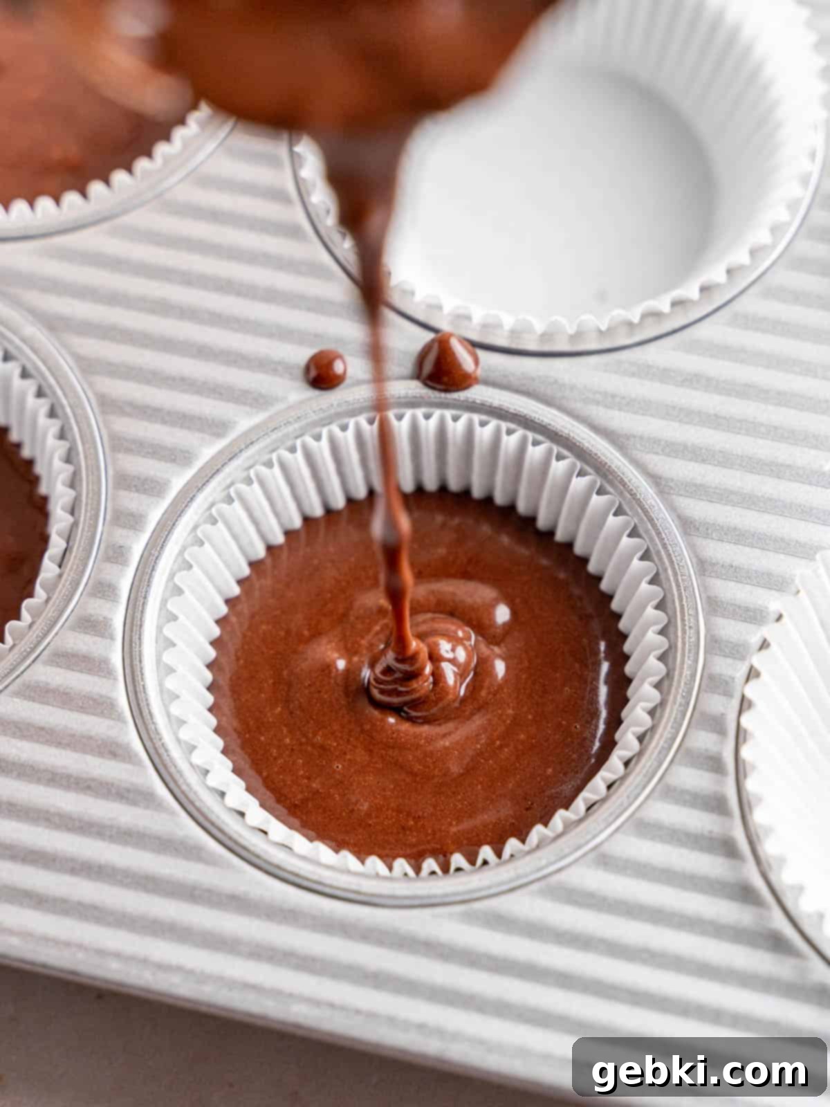 Minty Chocolate Indulgence 7 Filling cupcake liners with mint chocolate cupcake batter in a muffin tin.