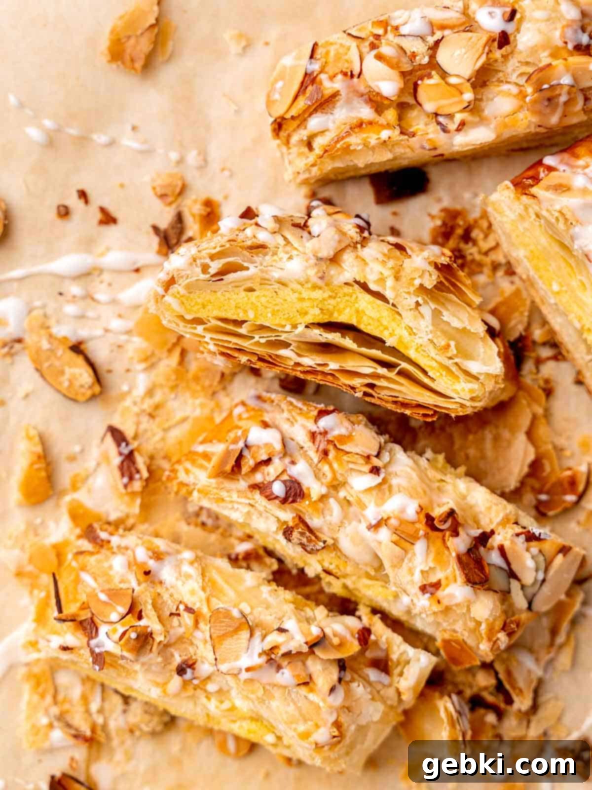 A beautifully braided almond danish, golden brown and sliced, showcasing its flaky layers and almond filling.
