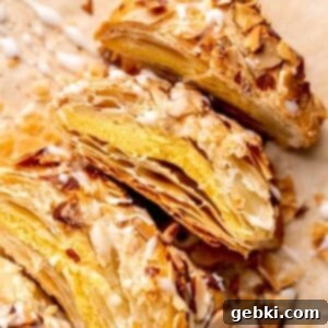 A beautifully braided almond danish with a sweet glaze, cut into perfect slices for serving.
