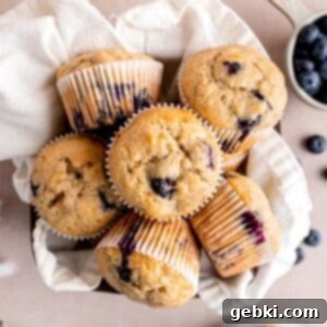 Irresistible Blueberry Banana Muffins 10 Blueberry banana muffins in a basket with a towel.