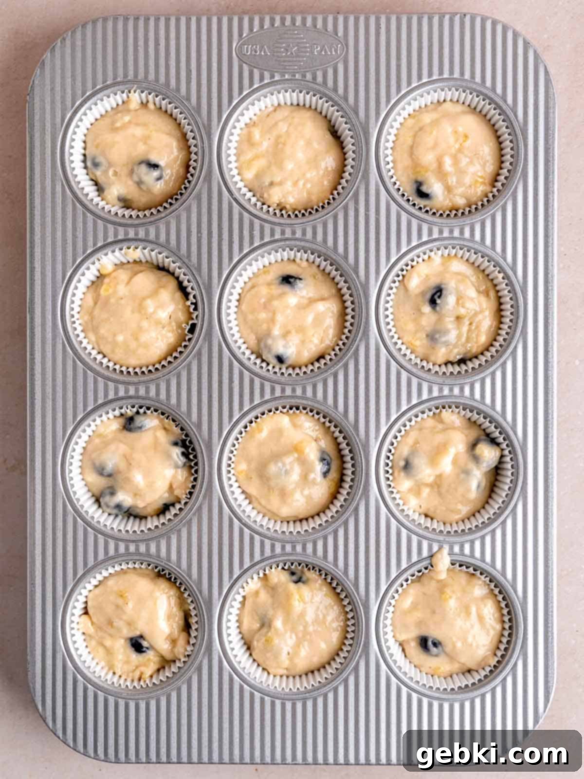 Irresistible Blueberry Banana Muffins 7 A muffin pan filled with banana blueberry batter.