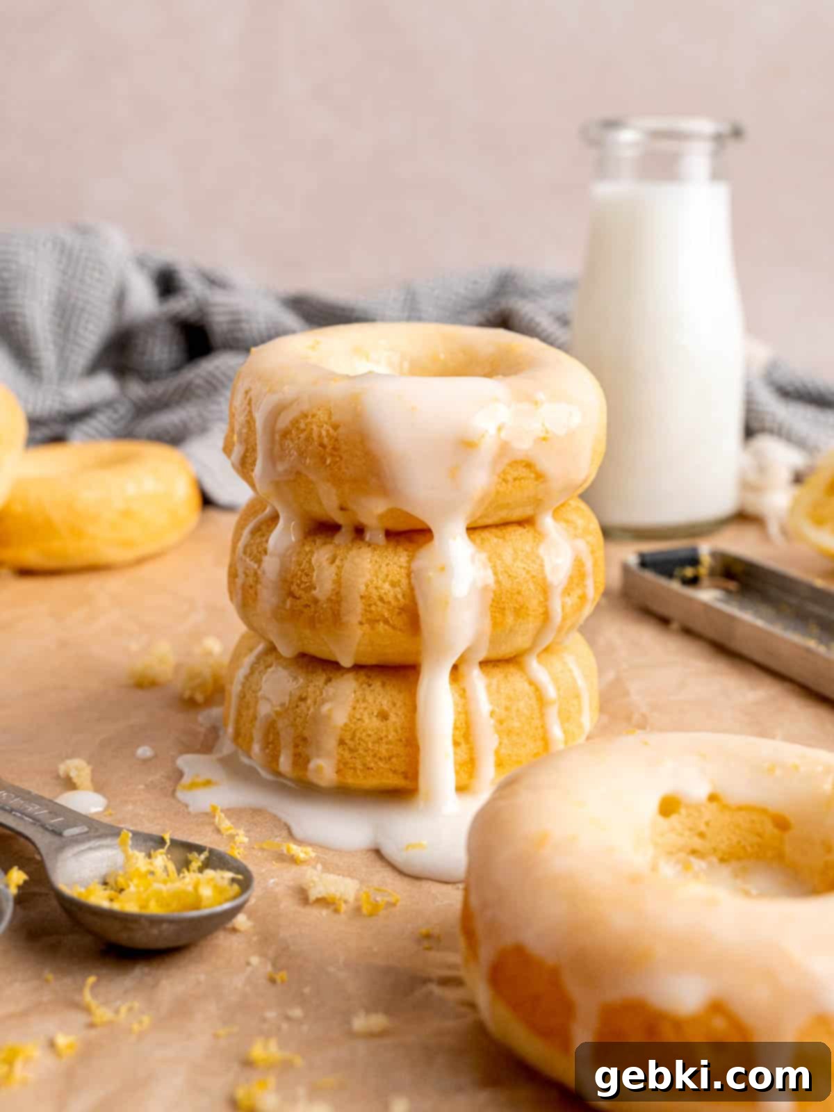 A stack of baked lemon donuts with icing, showcasing their fluffy texture and bright glaze.