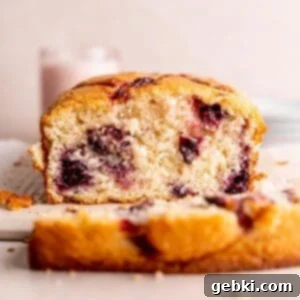 A cherry loaf cake with a slice cut off of the end.