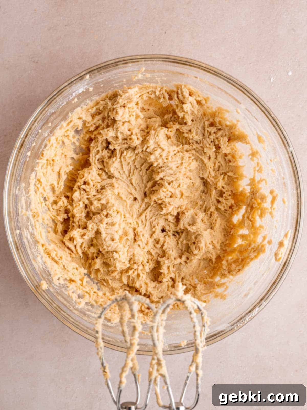 Irresistible White Chocolate Macadamia Nut Cookies 5 Cookie dough mixed together in a bowl using a hand mixer.