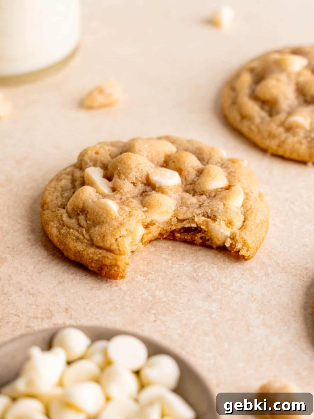 Irresistible White Chocolate Macadamia Nut Cookies 8 A white chocolate chip macadamia nut cookie with a bite taken out of it.
