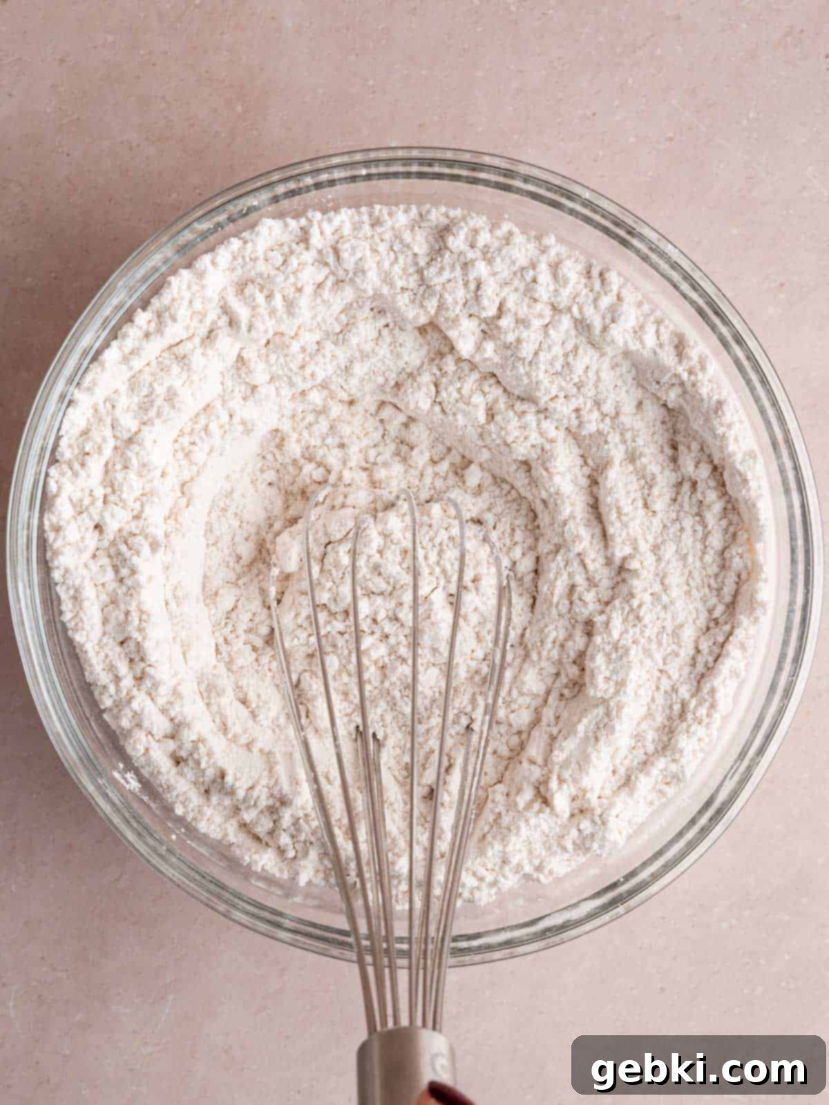 Whisking flour, baking soda, and salt in a bowl.