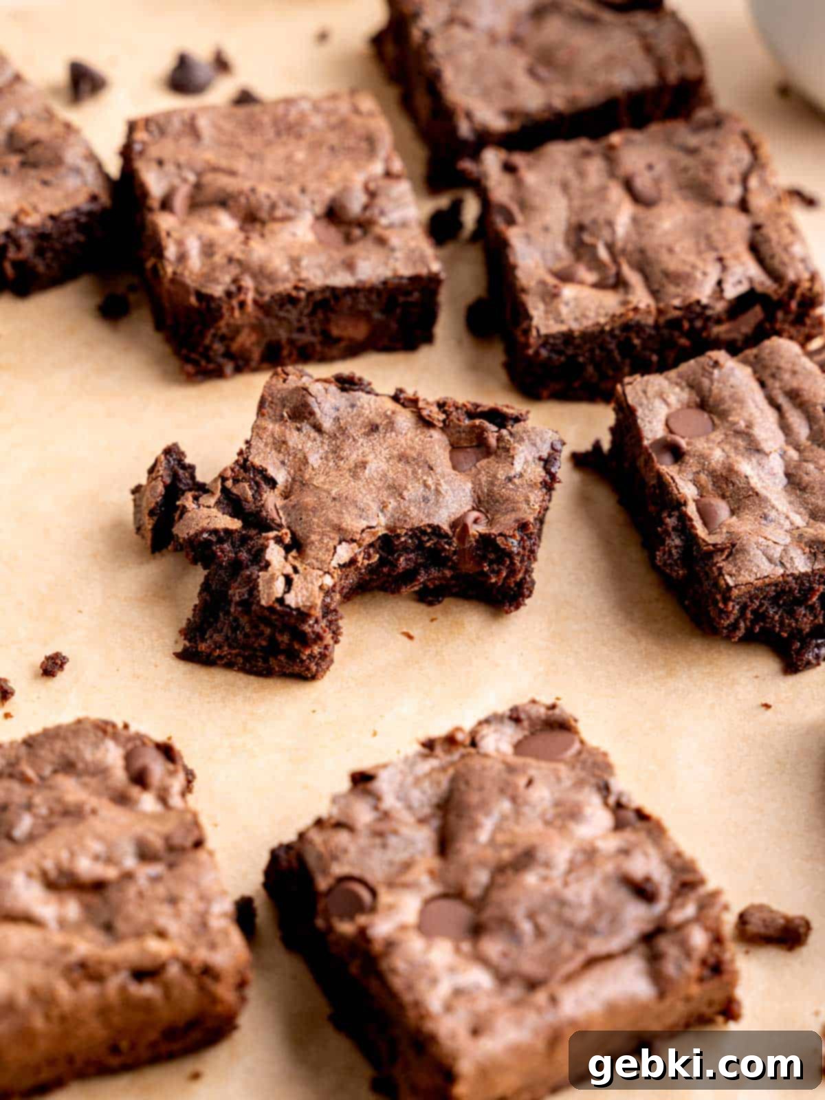 Several sourdough brownies cut into neat squares, with one showing a bite taken out, highlighting its rich, fudgy texture.