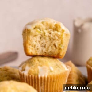 A stack of golden brown lemon zucchini muffins with lemon icing, ready to be enjoyed.