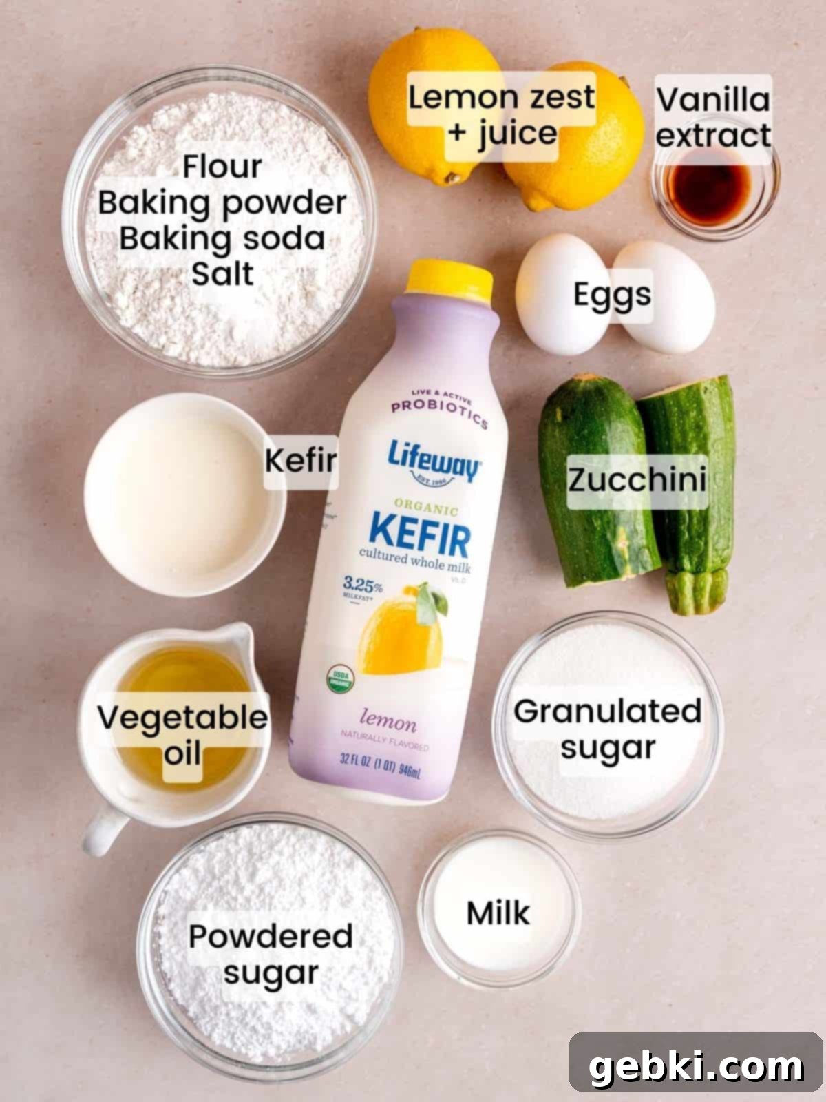 All the necessary ingredients laid out on a counter for making lemon zucchini muffins.