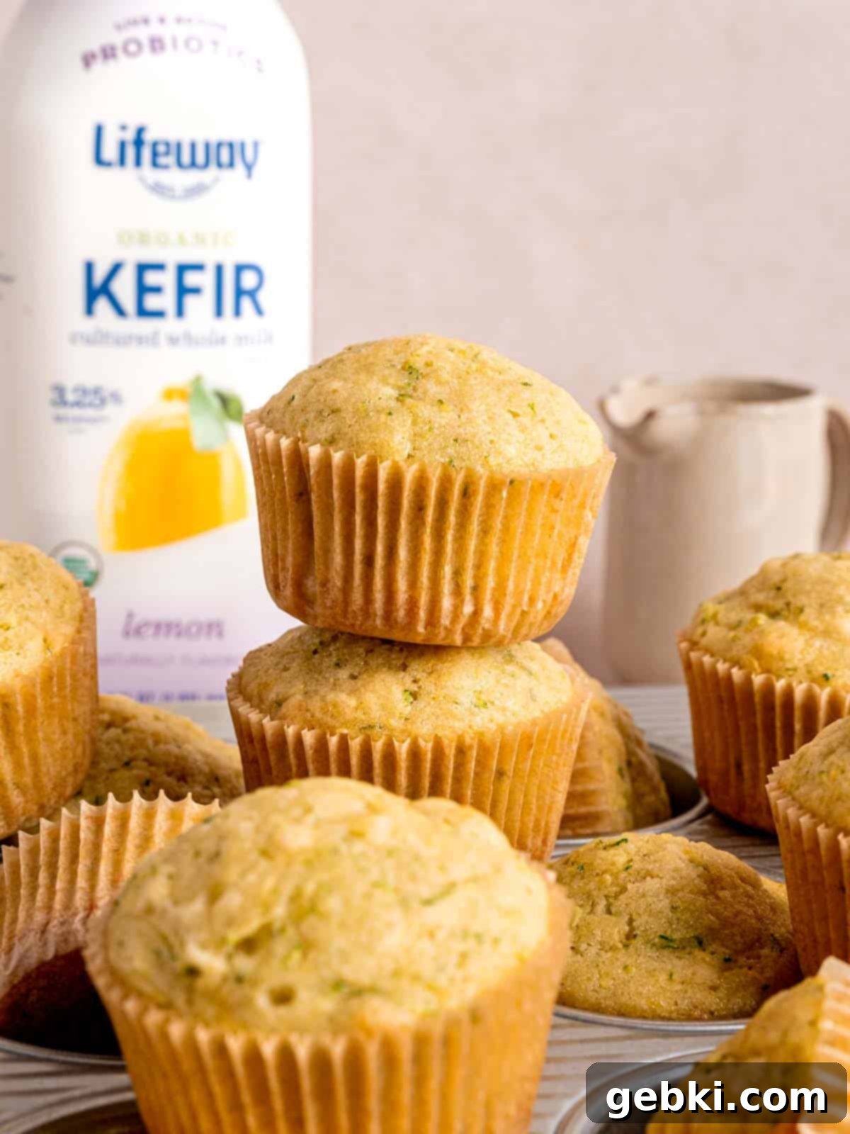Freshly baked lemon muffins with zucchini sitting beside a bottle of Lifeway Lemon Kefir.