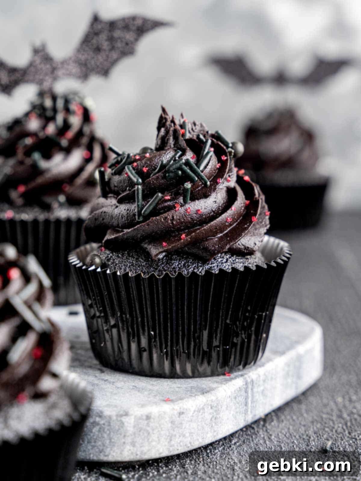 A black velvet cupcake with black cocoa buttercream frosting and sprinkles.