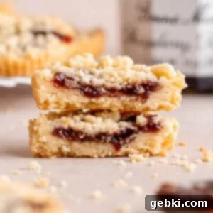 Simply Superior Easy Raspberry Crumble Cookies 12 Two halves of a raspberry crumble cookie stacked on top of each other, displaying the delicious filling.