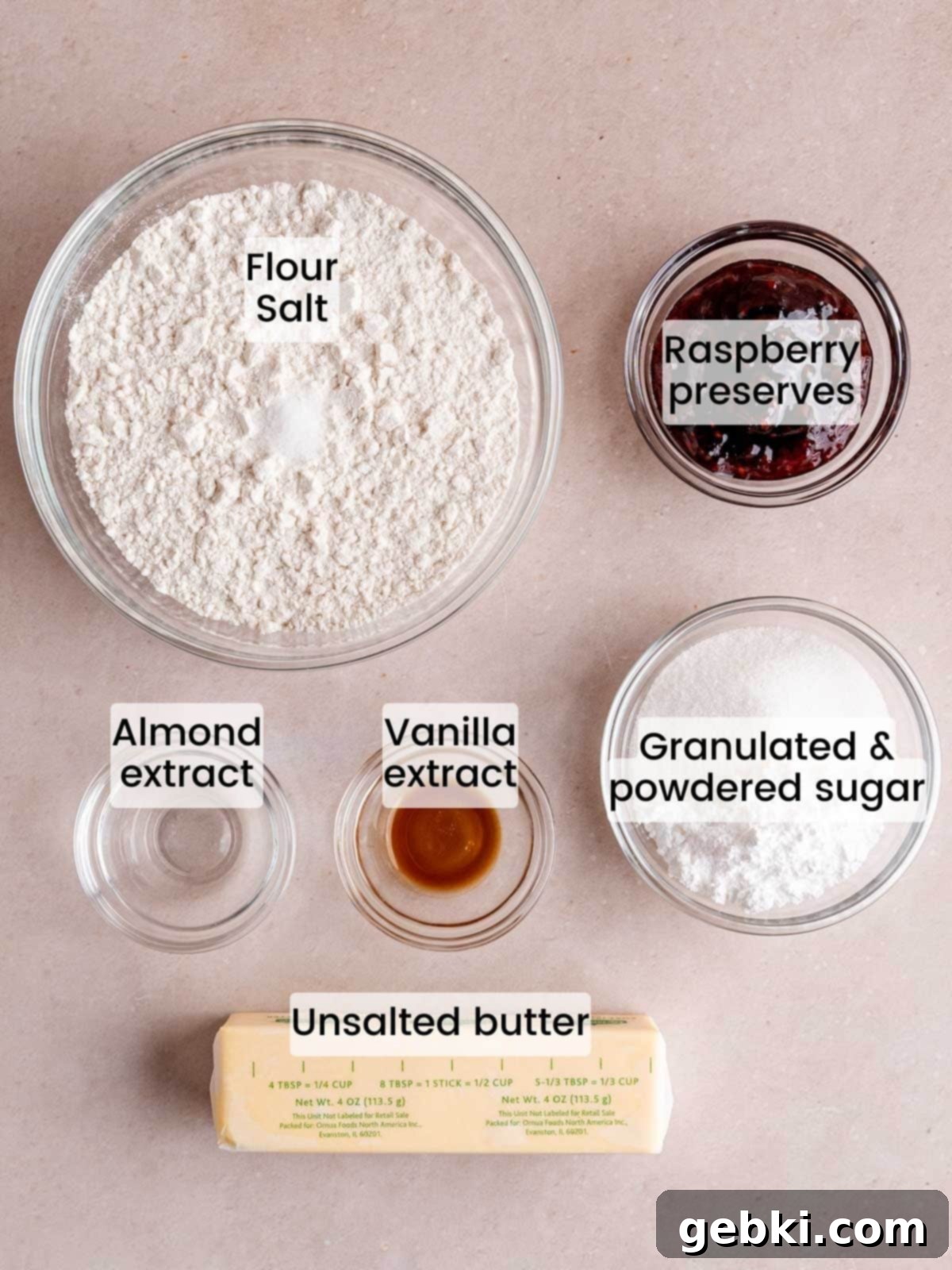 Simply Superior Easy Raspberry Crumble Cookies 3 A flat lay image showing all the ingredients needed to make raspberry crumble cookies, including butter, sugars, flour, extracts, and raspberry jam.