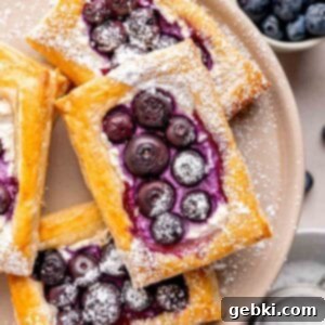 Simple Blueberry Cream Cheese Puffs 11 Blueberry cheese puff pastries dusted with powdered sugar, ready to be served.