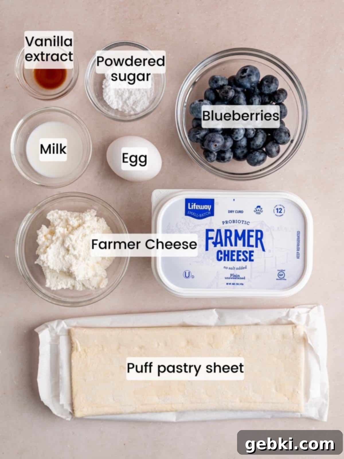 Simple Blueberry Cream Cheese Puffs 3 Ingredients needed to make blueberry danishes with frozen puff pastry, including farmer cheese, blueberries, powdered sugar, and a sheet of puff pastry.