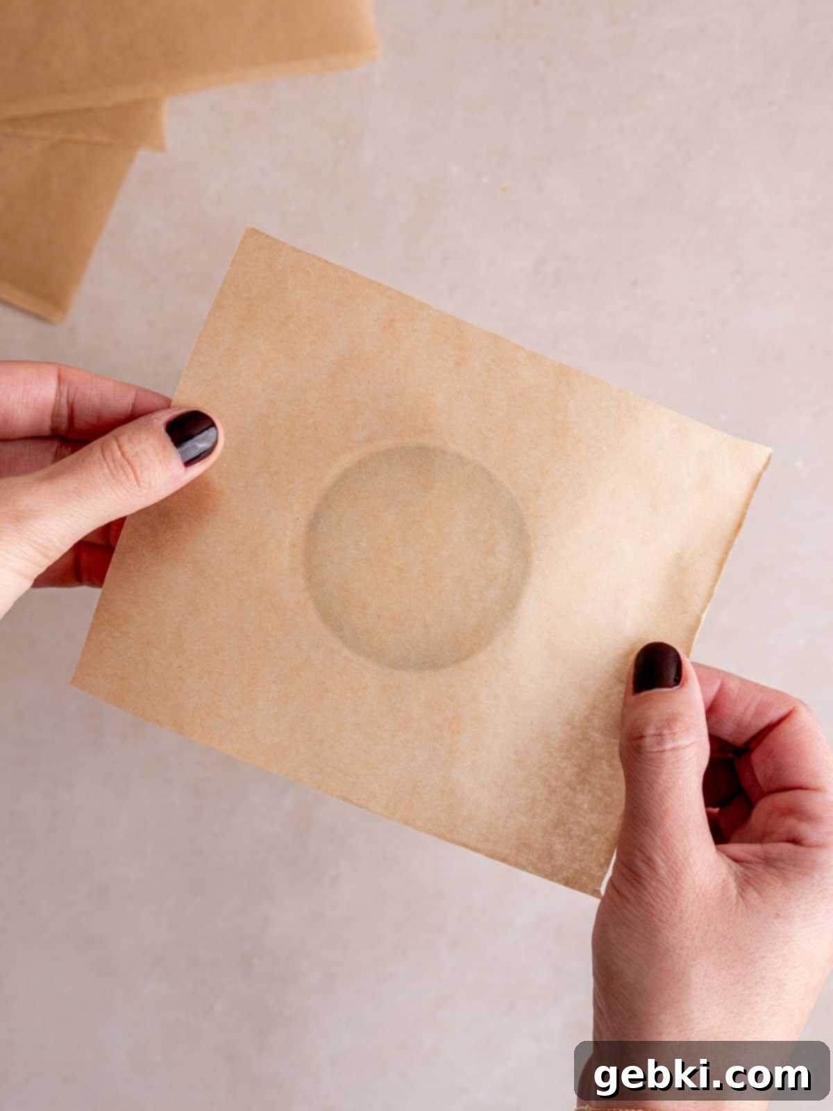 The Ultimate Guide To Homemade Muffin Liners 8 Holding a parchment paper square over the bottom of a pint glass.