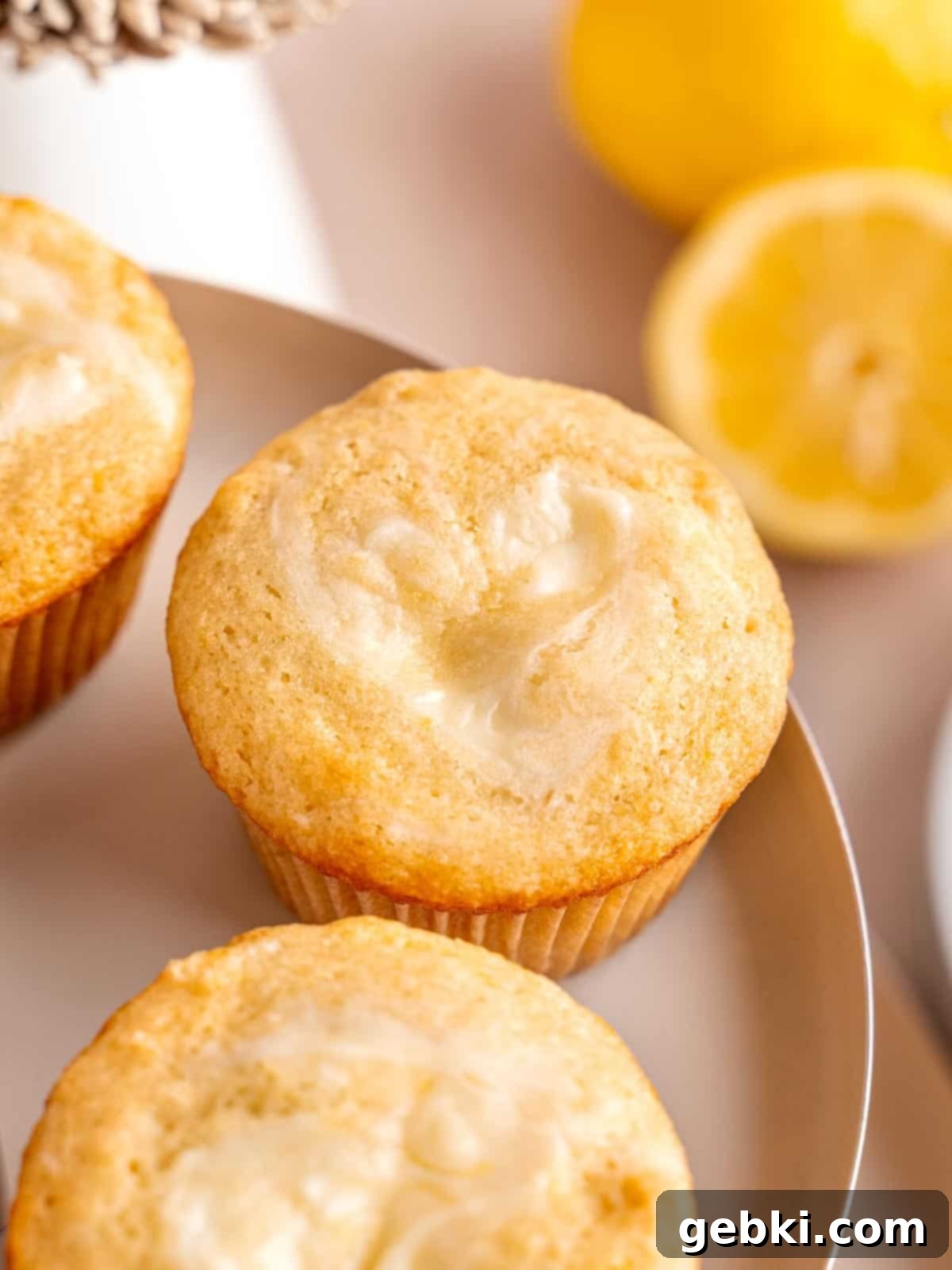 Heavenly Lemon Cream Cheese Muffins 2 A perfectly baked lemon muffin featuring a delicate cream cheese swirl on top, glistening slightly in natural light.