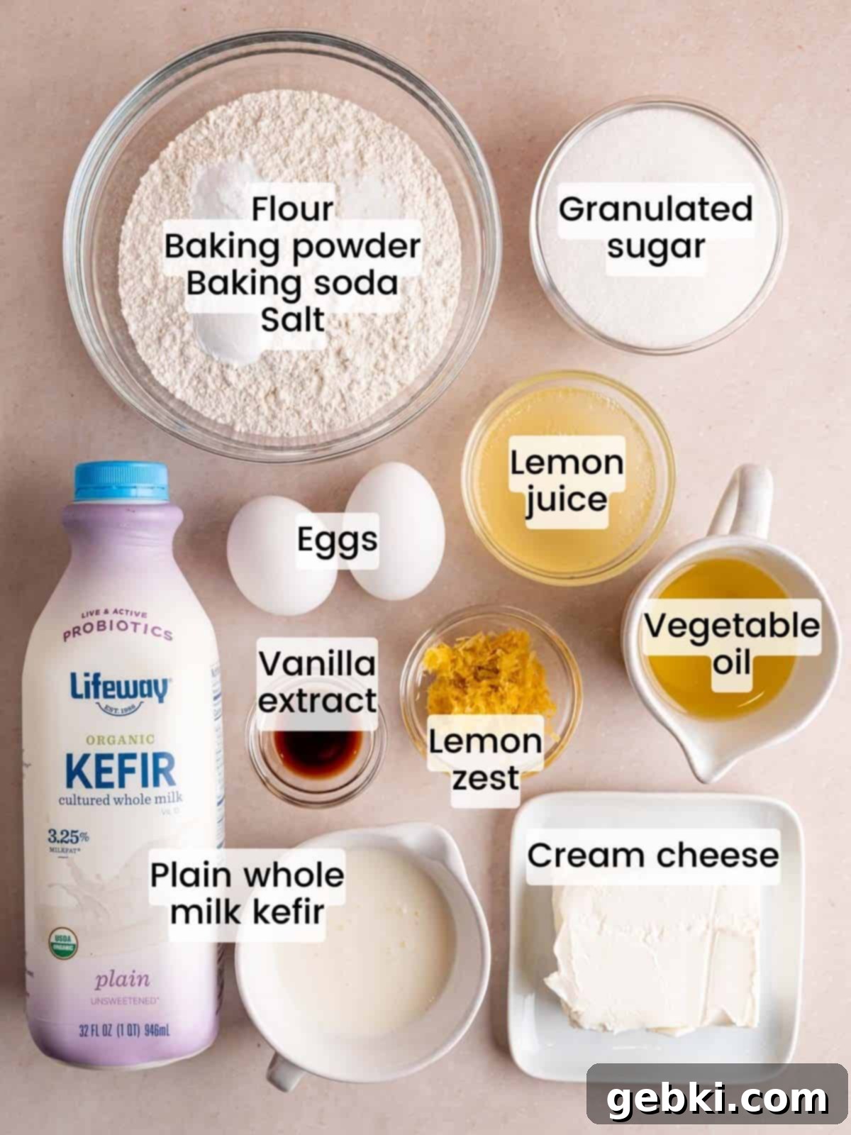 Heavenly Lemon Cream Cheese Muffins 3 A flat lay of all the fresh ingredients required to bake delicious lemon cream cheese muffins, including lemons, flour, eggs, and cream cheese.