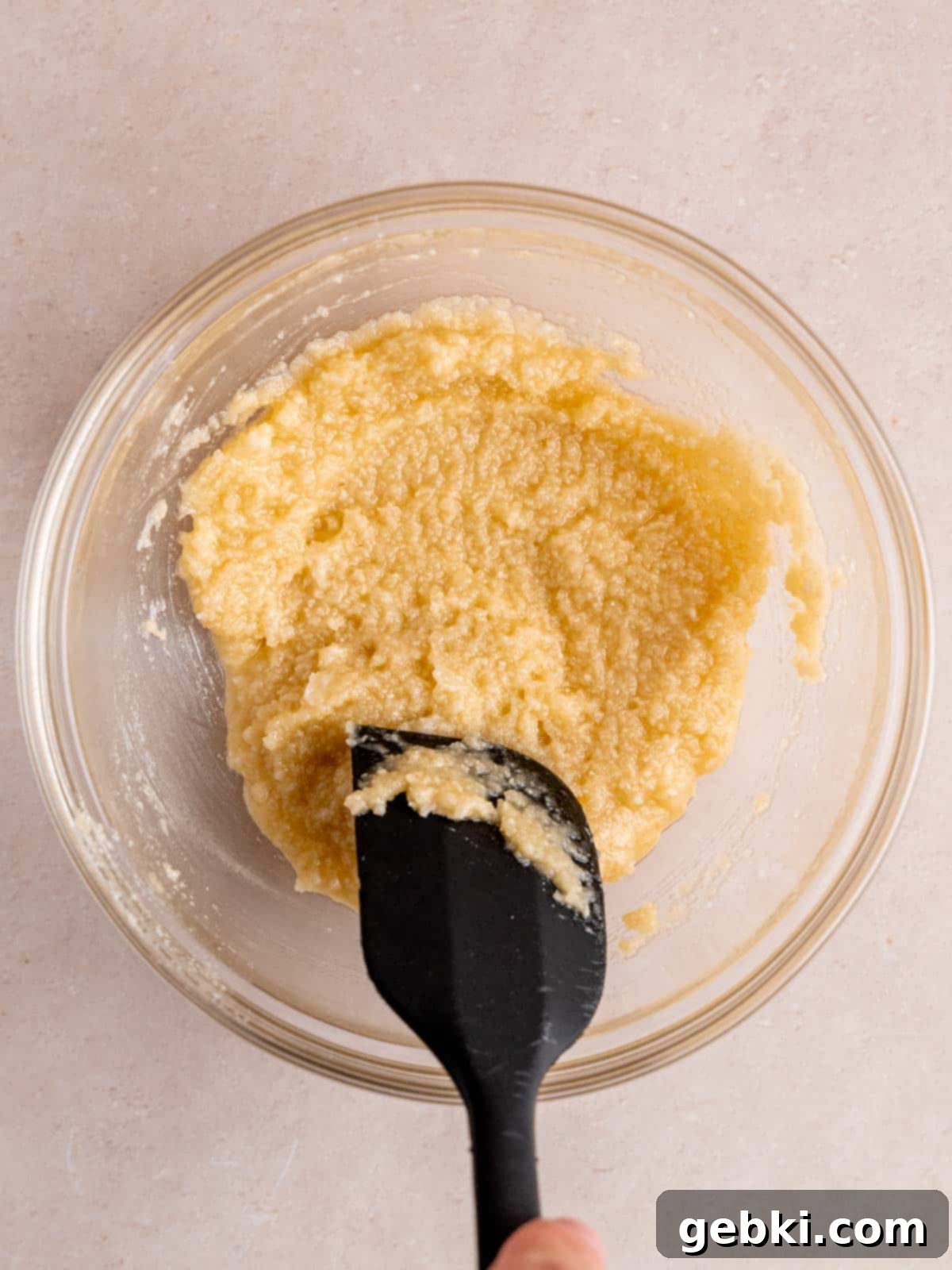 Close-up of a small bowl containing a smooth, creamy almond filling mixture, ready for use in the cookies.