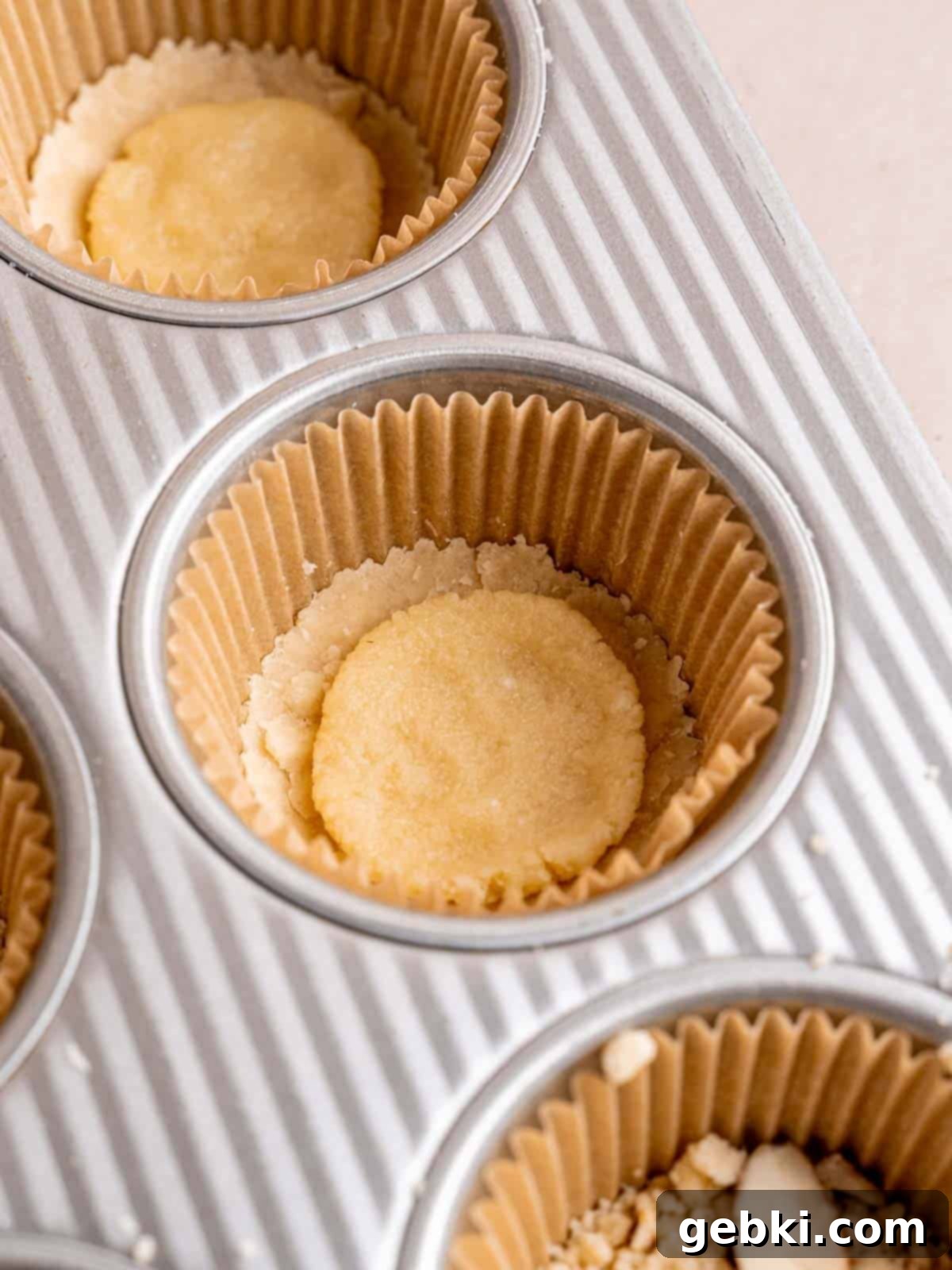 Shortbread cookies with a scoop of almond filling placed precisely in the center of each base, ready for the next layer.