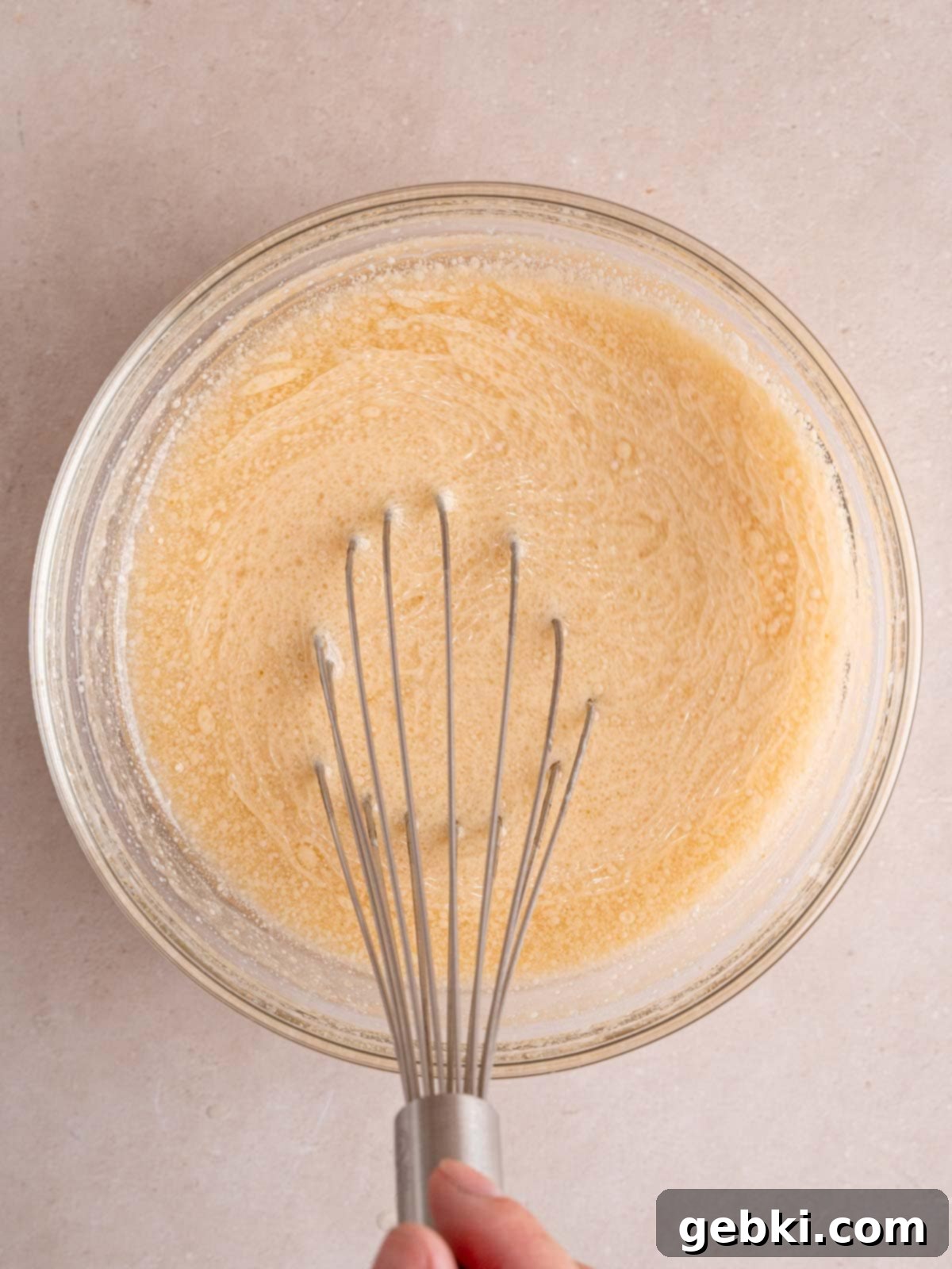 Whisking eggs, vegetable oil, vanilla extract, and kefir in a bowl.