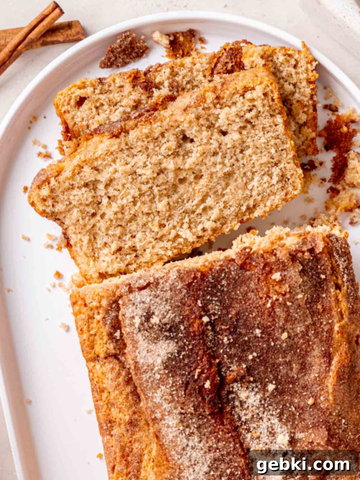 A loaf of snickerdoodle bread with a crunchy cinnamon sugar topping, ready to be sliced and enjoyed.