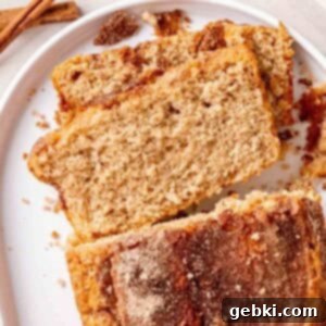 A freshly baked loaf of Snickerdoodle Bread with a perfectly golden, crunchy cinnamon sugar topping.