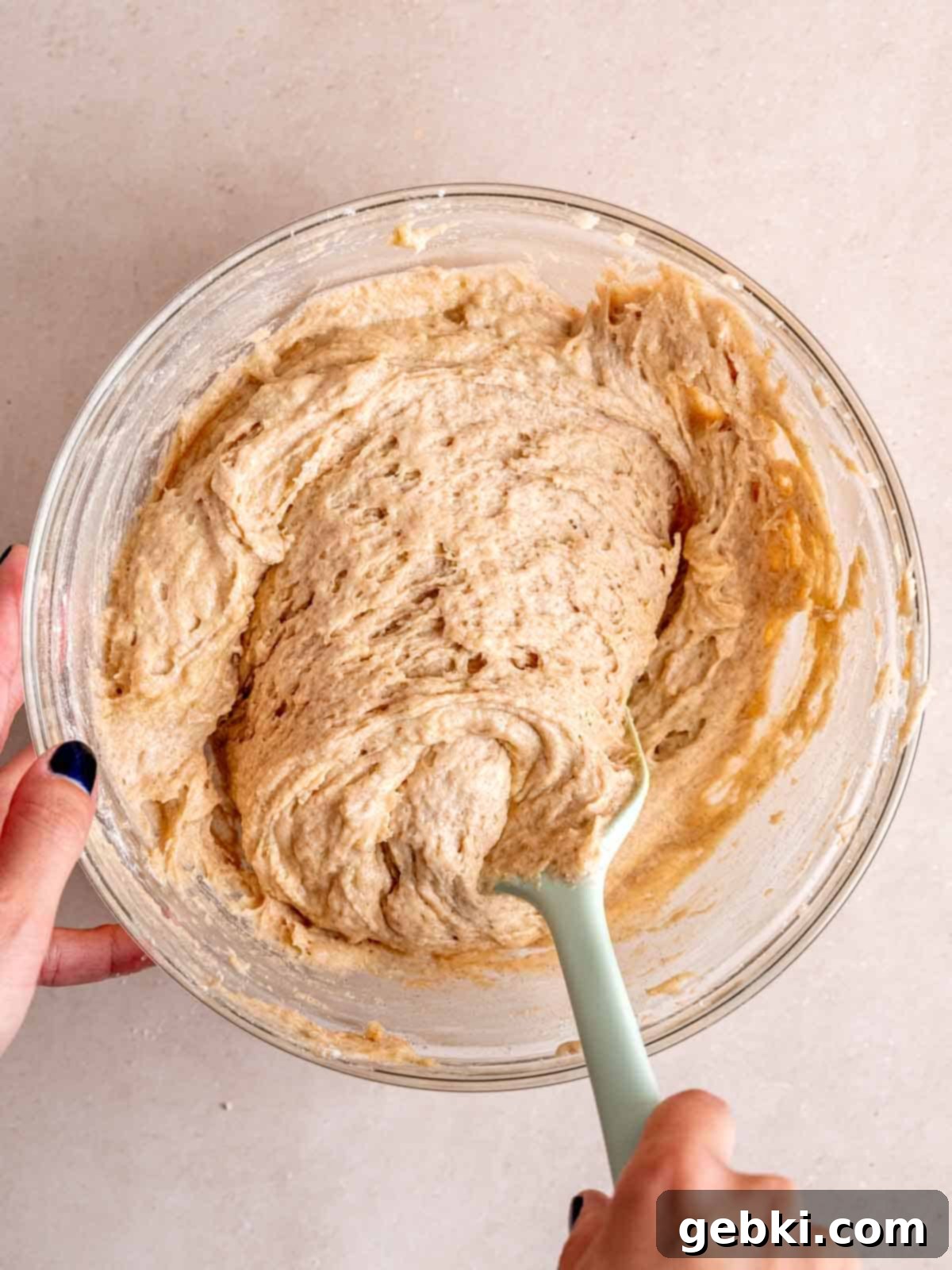Snickerdoodle cake batter in a bowl with a spatula, showing a perfectly combined mixture before baking.