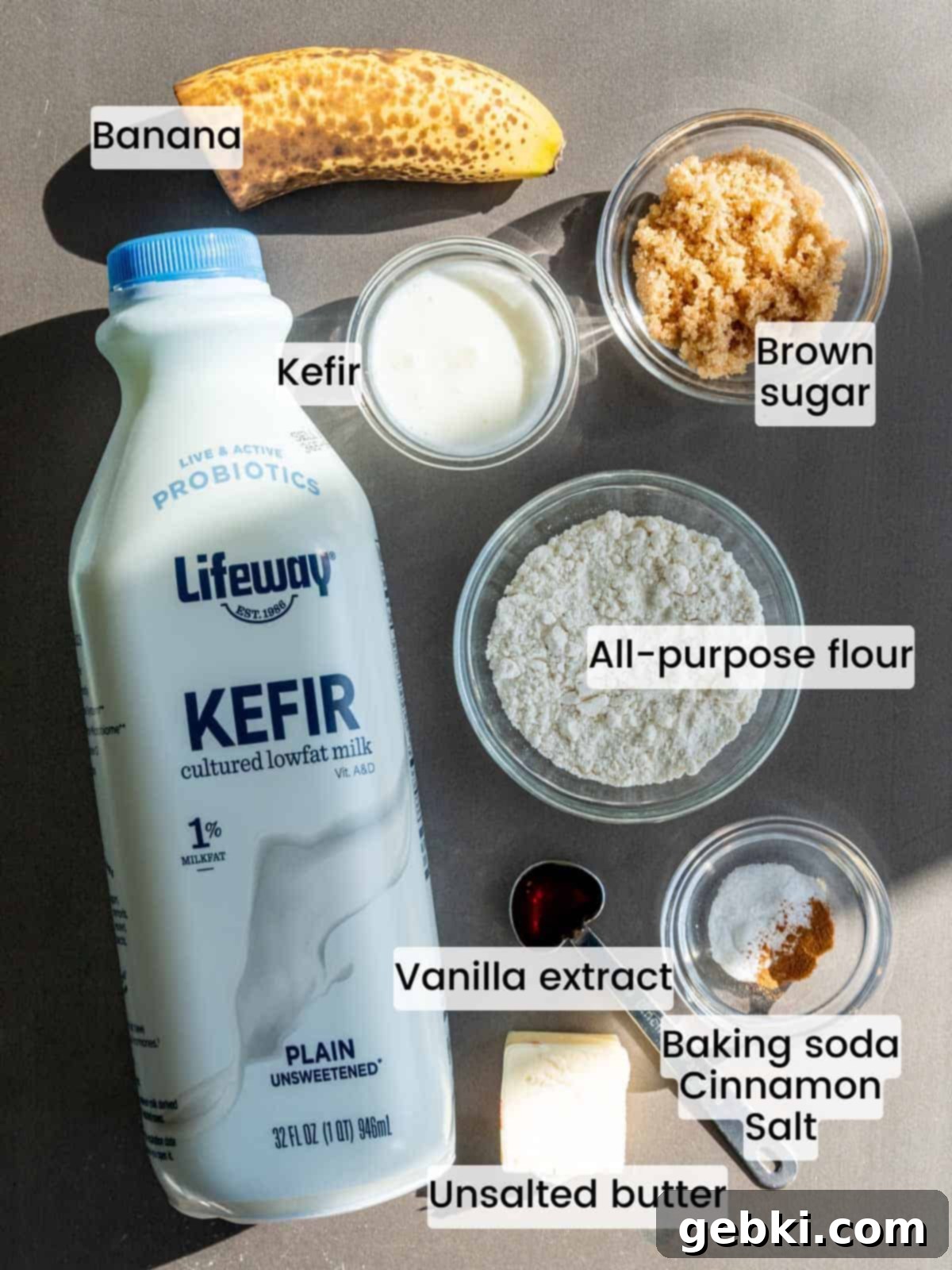 Speedy Eggless Banana Bread Mug Cake 3 A flat lay of all the ingredients needed to make a single serving of moist banana bread in a mug: overripe banana, brown sugar, flour, kefir, butter, vanilla, cinnamon, salt, and baking soda.