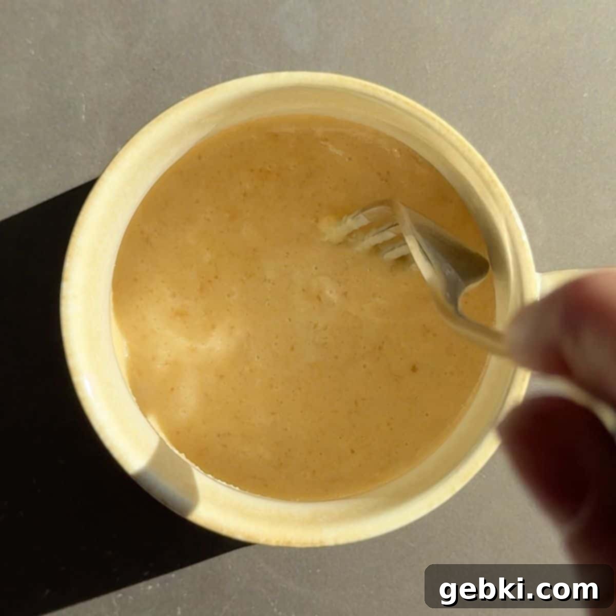 Speedy Eggless Banana Bread Mug Cake 5 Melted butter mixed with brown sugar, vanilla extract, and kefir in a mug.