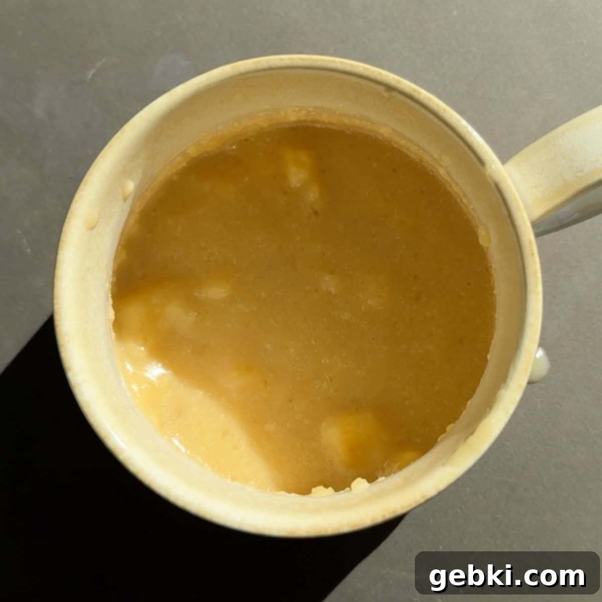 Speedy Eggless Banana Bread Mug Cake 7 The wet ingredients with mashed banana in a mug, after adding salt, cinnamon, and baking soda.