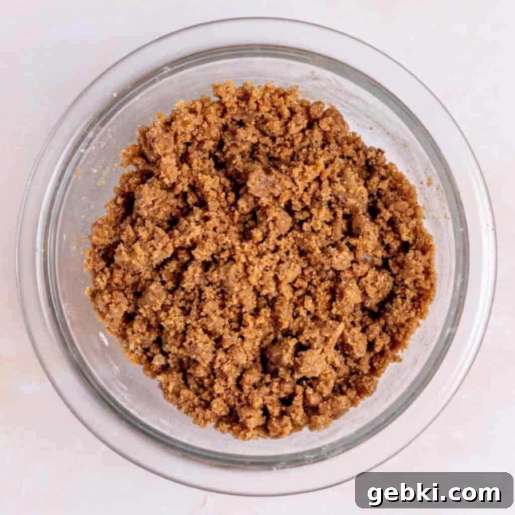 Tangy Sourdough Discard Coffee Cake 5 Cinnamon crumb topping mixture in a bowl, resembling wet sand.