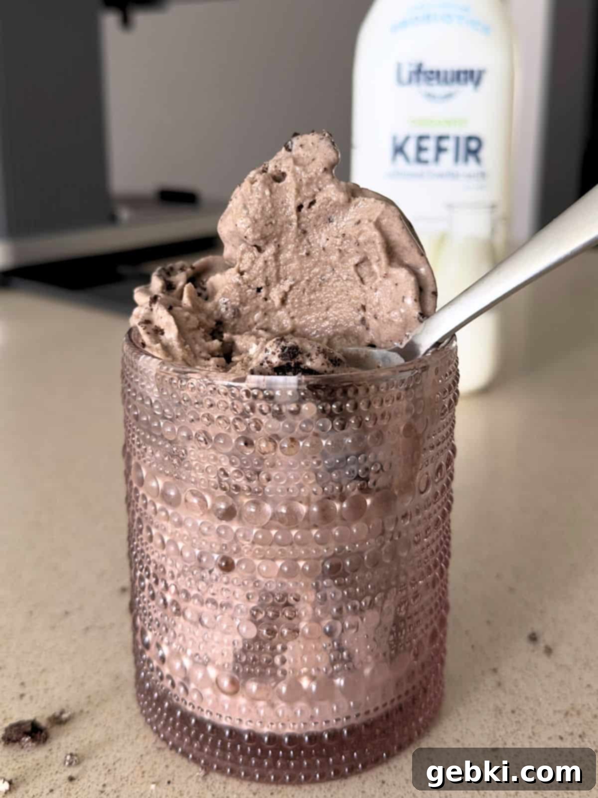 Simple Ninja Creami Cookies and Cream Kefir Ice Cream 11 Cookies and cream kefir ice cream in a cup with a spoon.