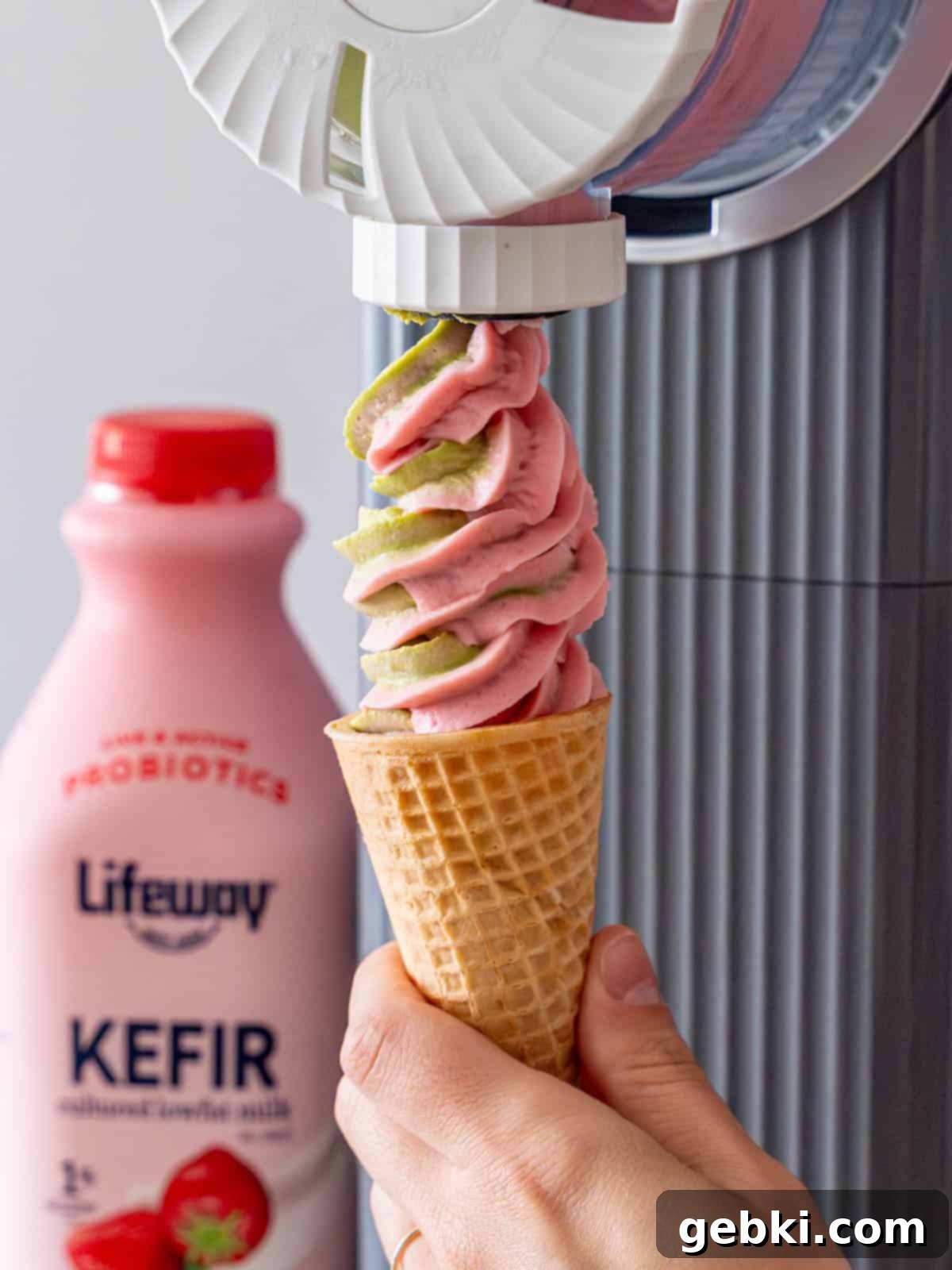 Strawberry Matcha Ninja Creami Treat 12 Swirling matcha and strawberry ice cream out of a Ninja Creami Swirl.