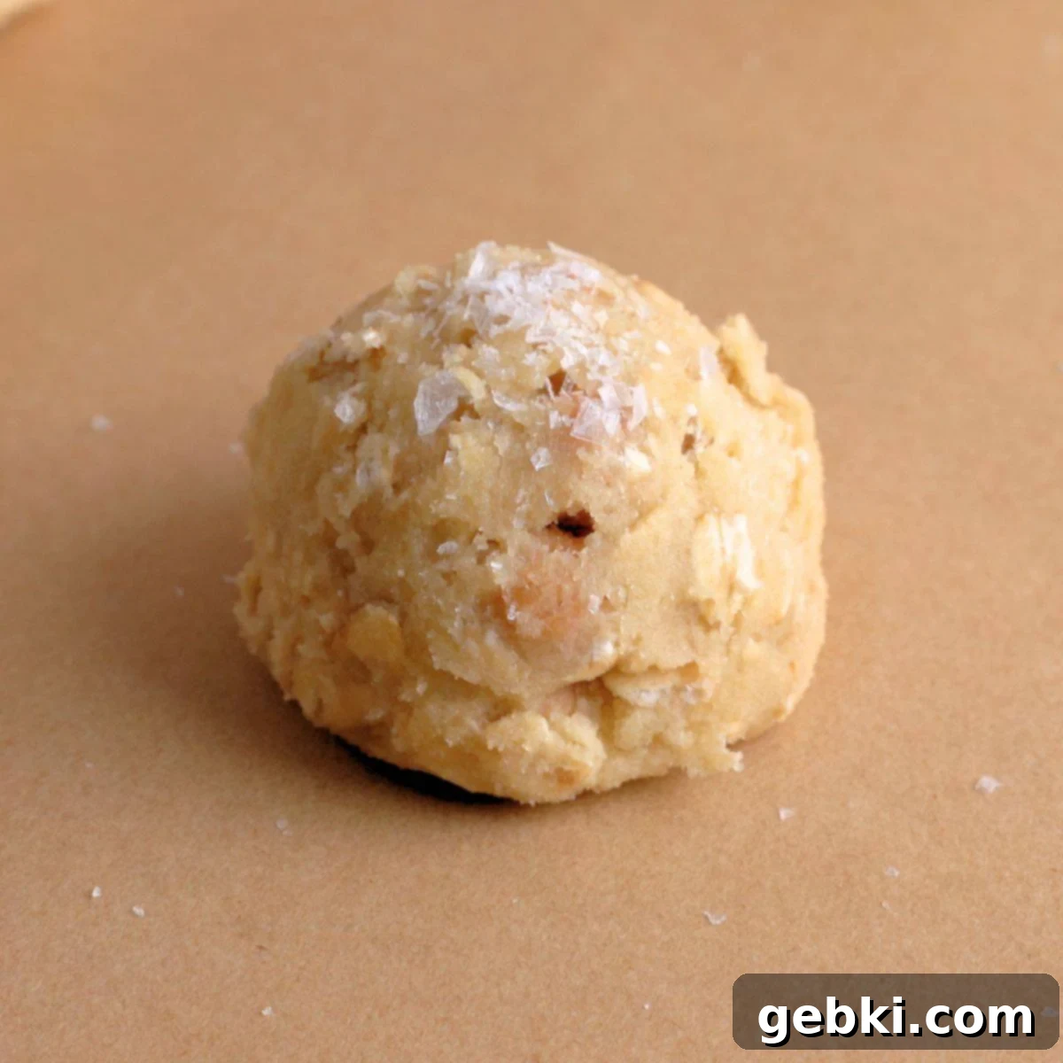 Irresistible Chewy Salted Caramel Oat Cookies 9 Dough ball for caramel oatmeal cookies topped with sea salt.