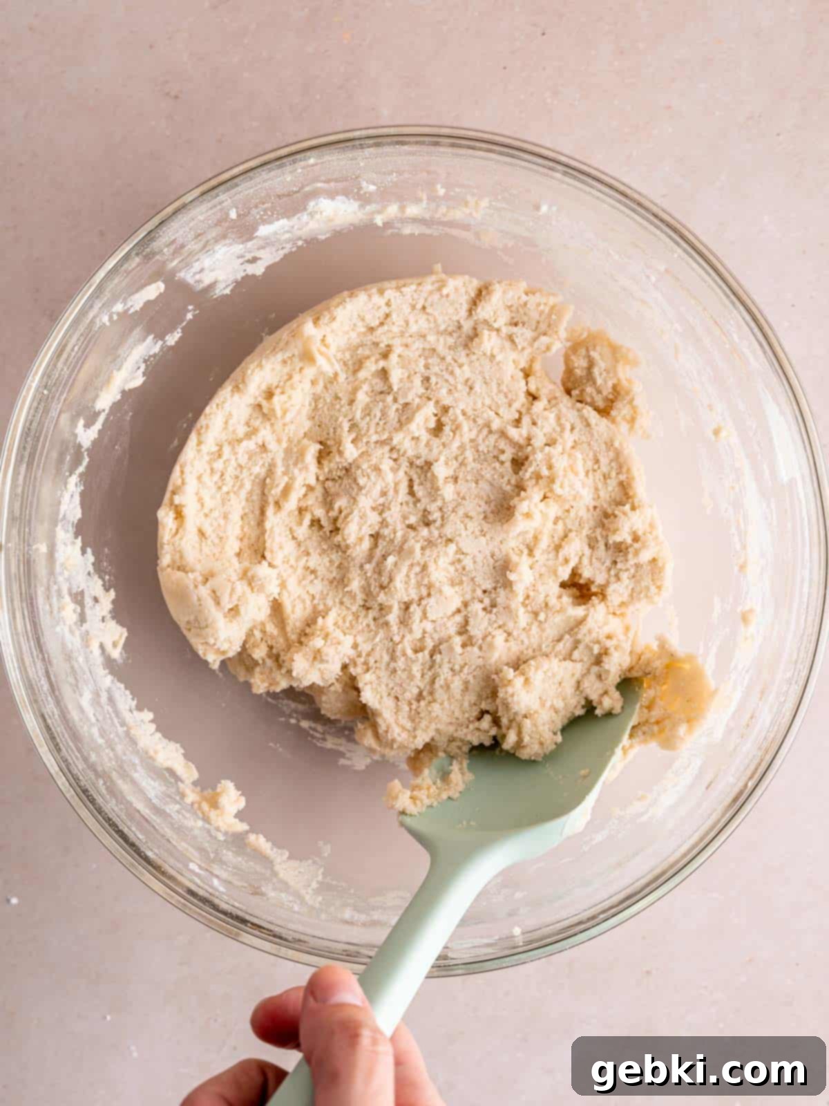 Lavender shortbread cookie dough in a bowl with a spatula.