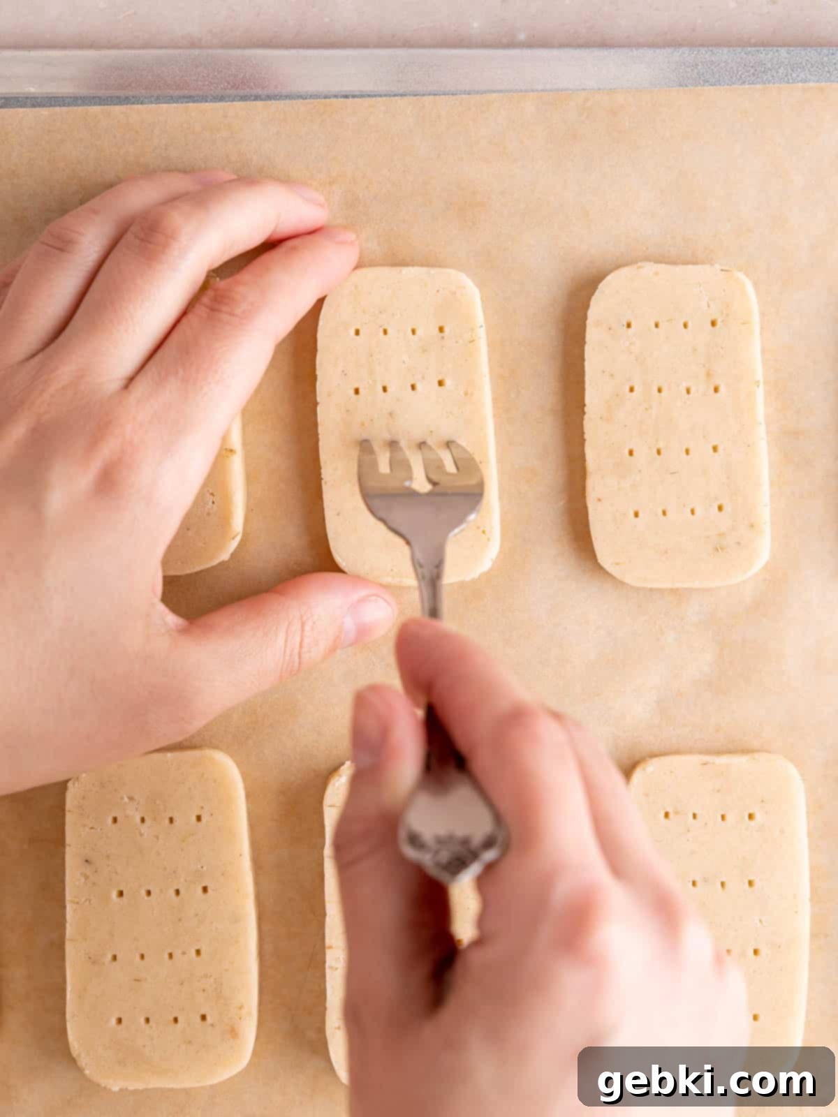 Poking lavender shortbread cookie dough rectangles with a fork.
