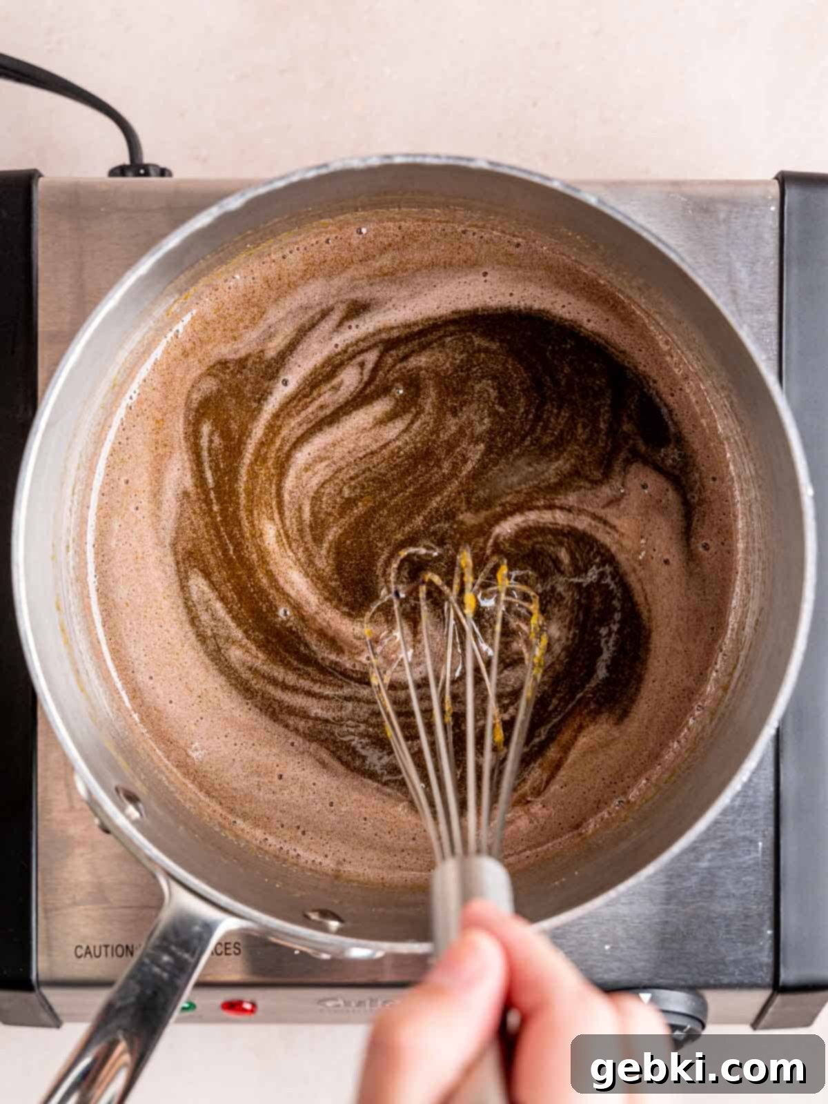Lavender Honey Dream 4 Whisking egg yolks, granulated sugar, honey, lavender syrup, and purple food coloring in a saucepan.