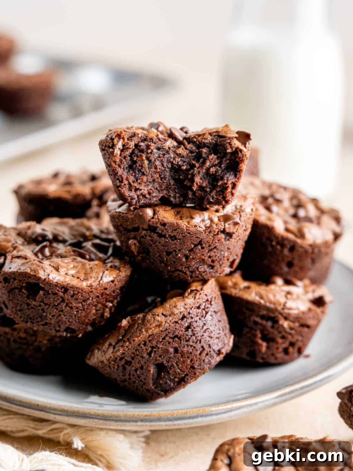 Perfectly Poppable Brownies 2 Mini brownie bites stacked on a plate.