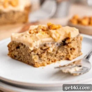 The Easiest Frosted Banana Cake Ever 11 A slice of banana snack cake on a plate with a fork.