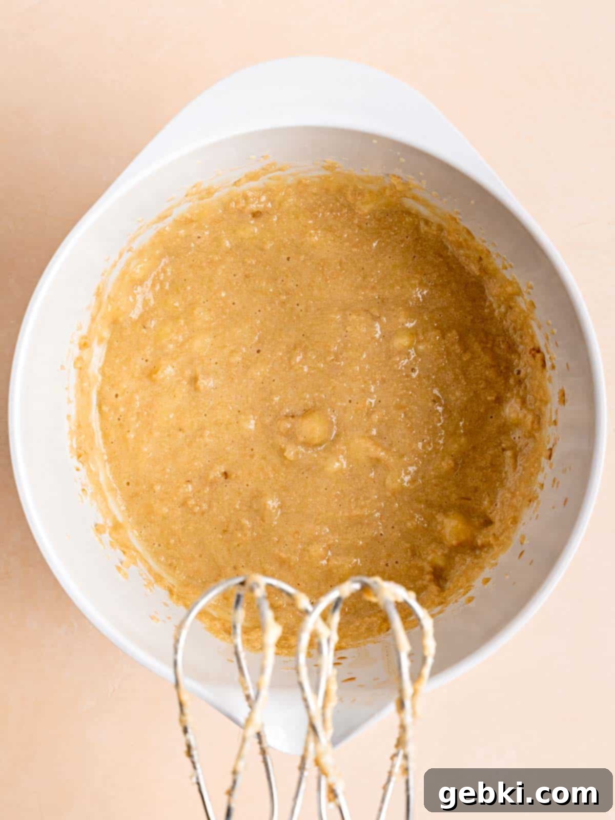 The Easiest Frosted Banana Cake Ever 5 Butter, brown sugar, egg, vanilla extract, sour cream, and bananas mixed in a bowl.