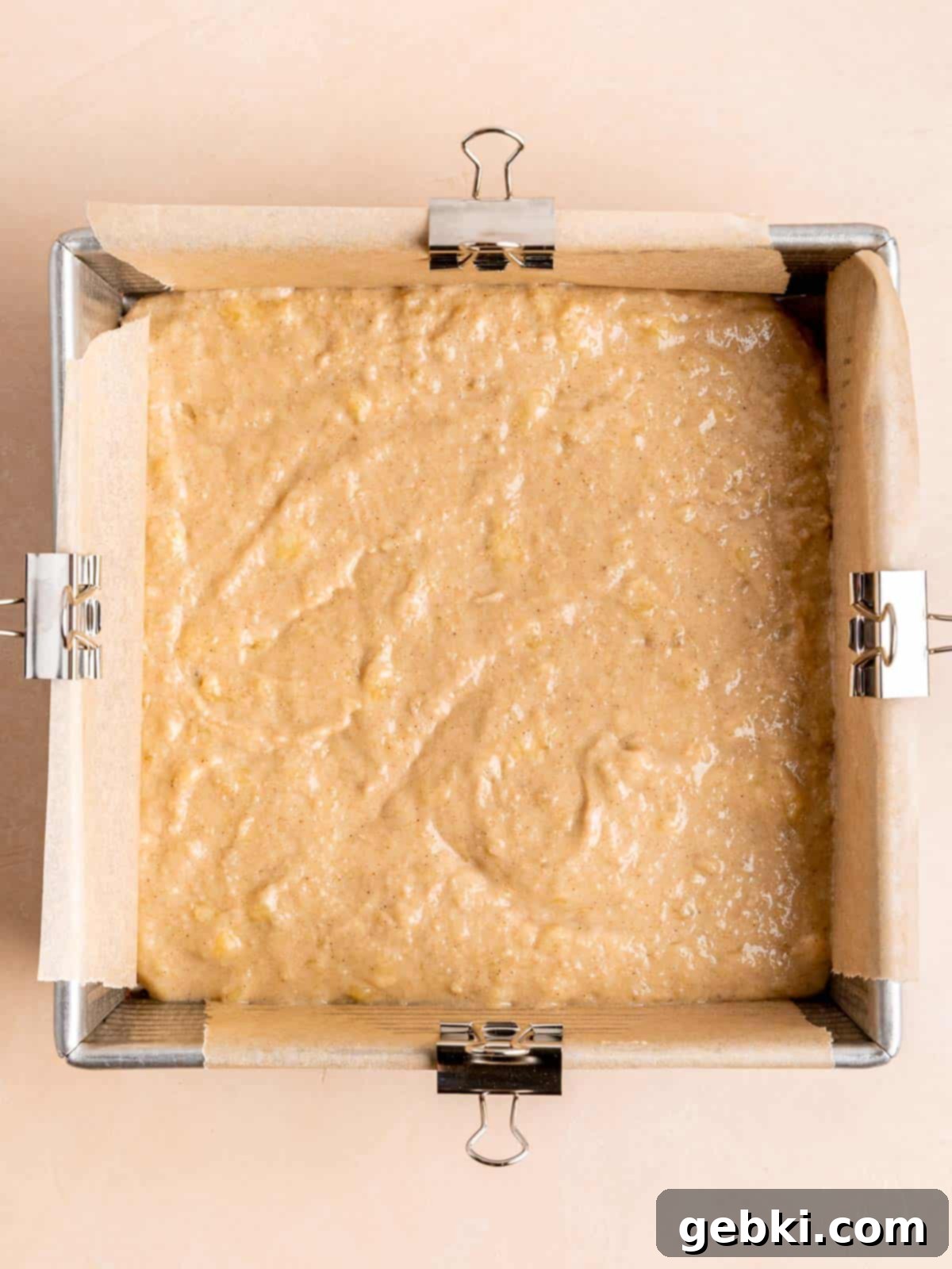 The Easiest Frosted Banana Cake Ever 6 Banana cake batter in an 8x8 inch pan lined with parchment paper.
