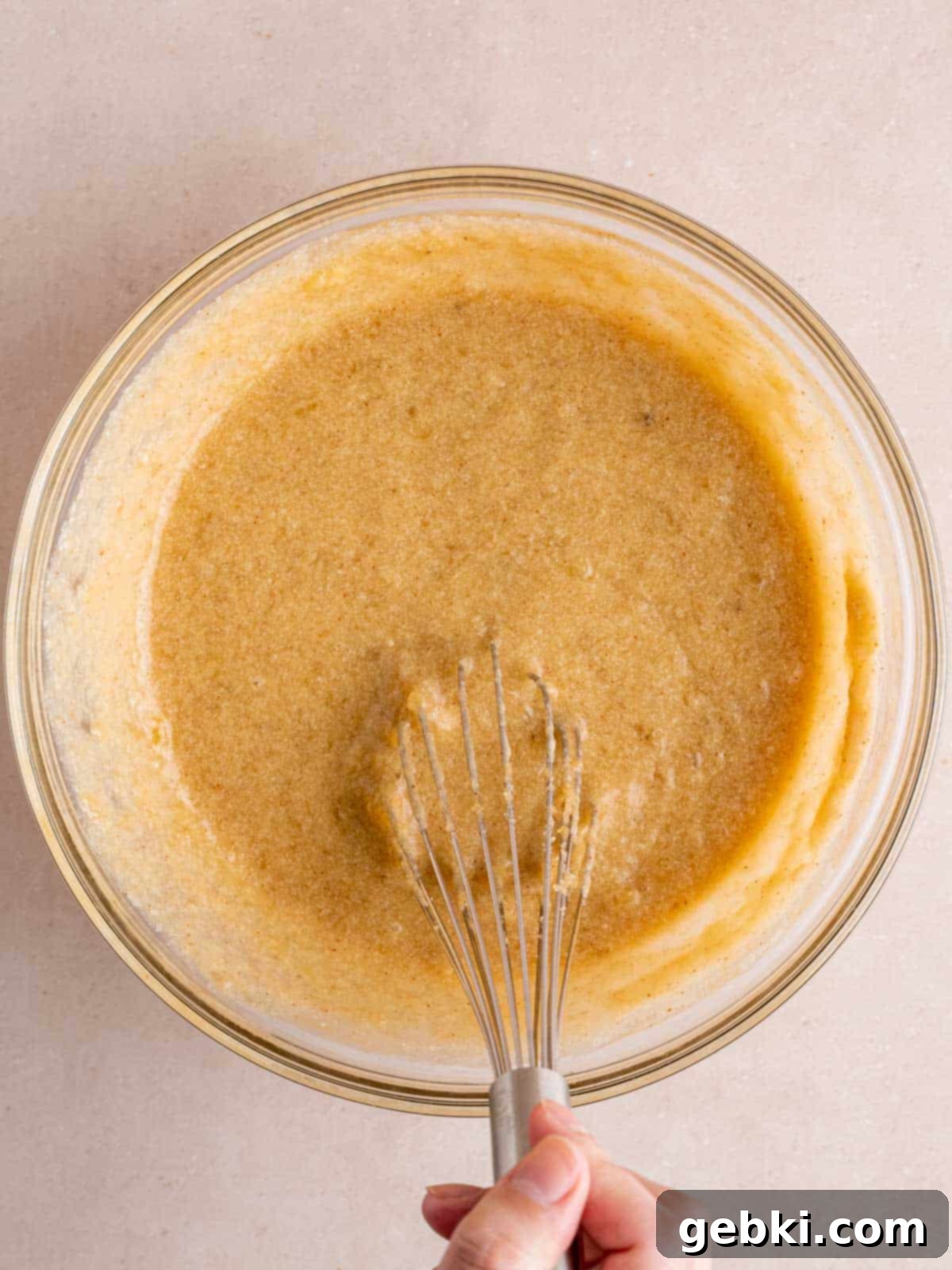 Banoffee Bliss Cupcakes 6 Whisking wet ingredients for banana cupcakes, including brown butter, sugars, eggs, vanilla, sour cream, and mashed bananas.