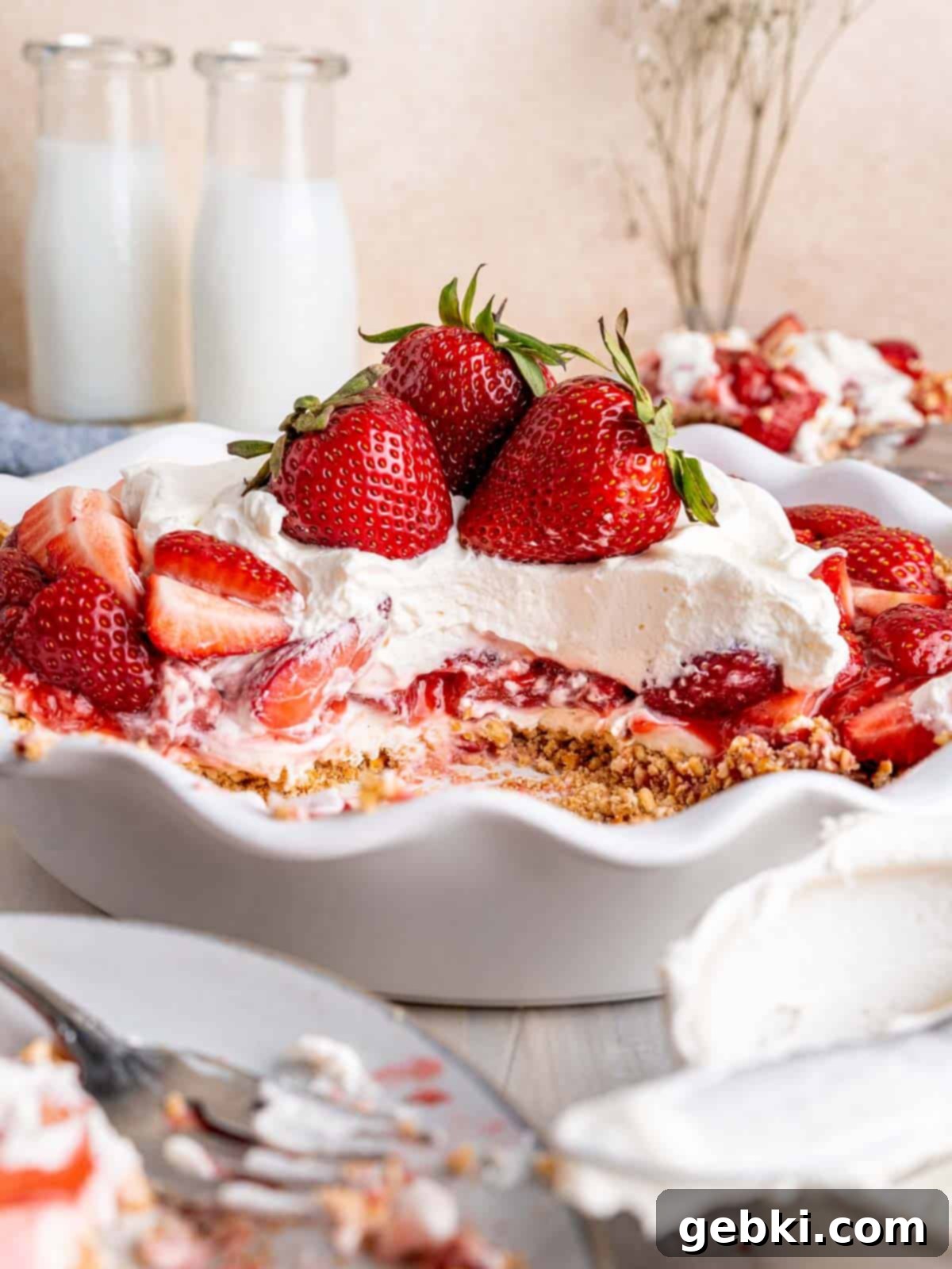 A strawberry cream cheese pie with a few slices taken out, showcasing its vibrant layers.