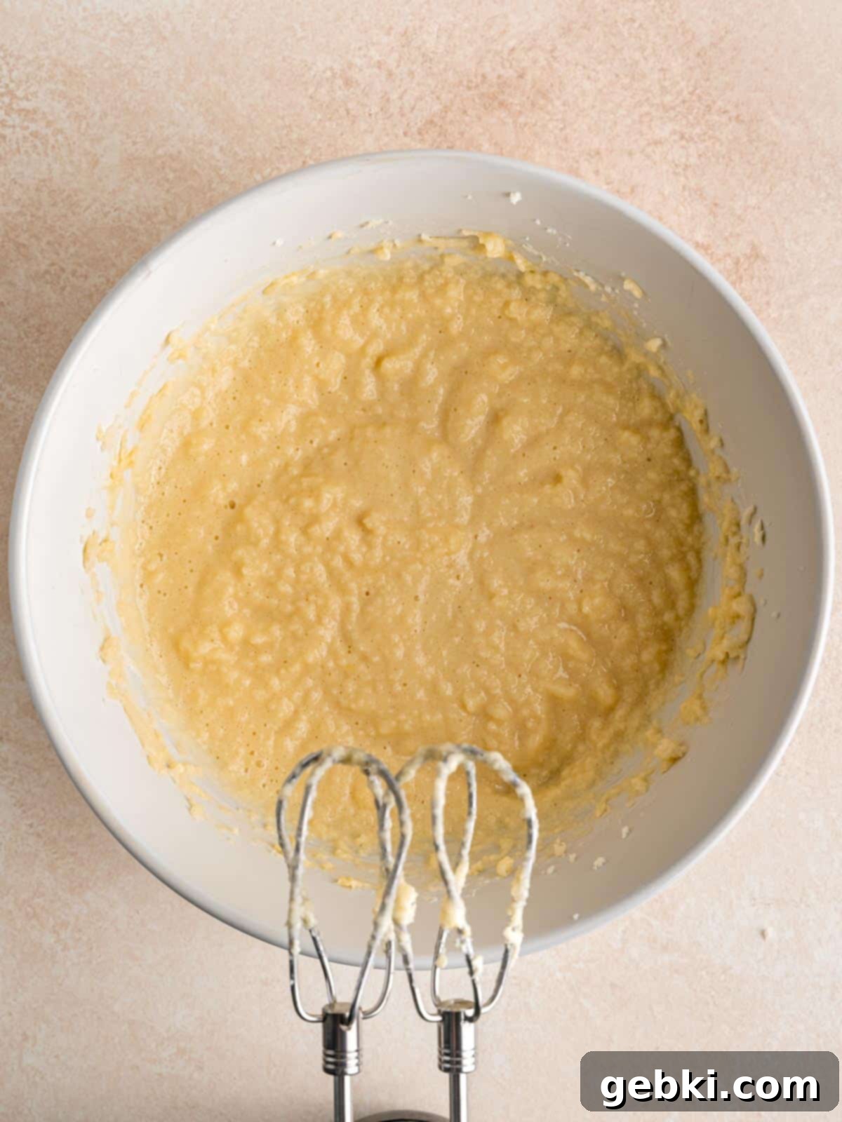 Effortless Honey Vanilla Delight 4 Wet cake ingredients in a bowl after being combined with a hand mixer, showing a creamy, light yellow mixture.