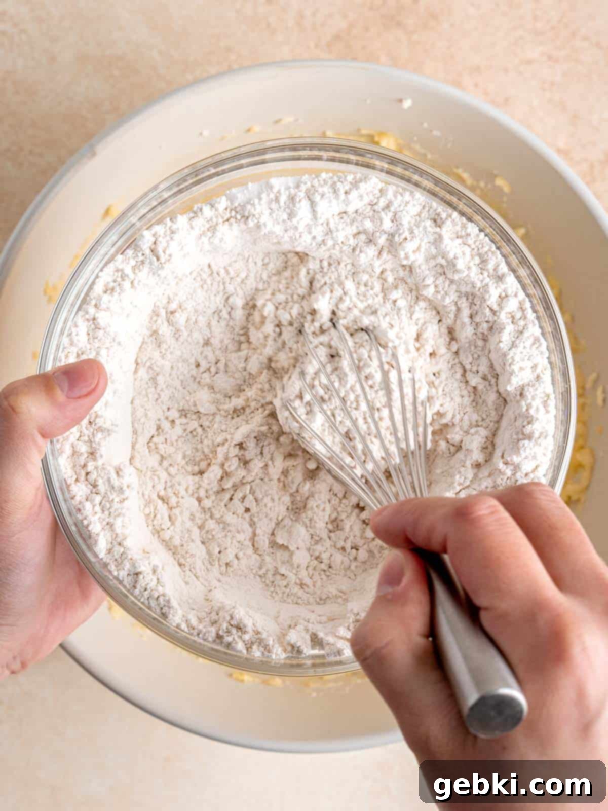 Effortless Honey Vanilla Delight 5 A bowl of dry cake ingredients, including flour, baking powder, and salt, being whisked together.