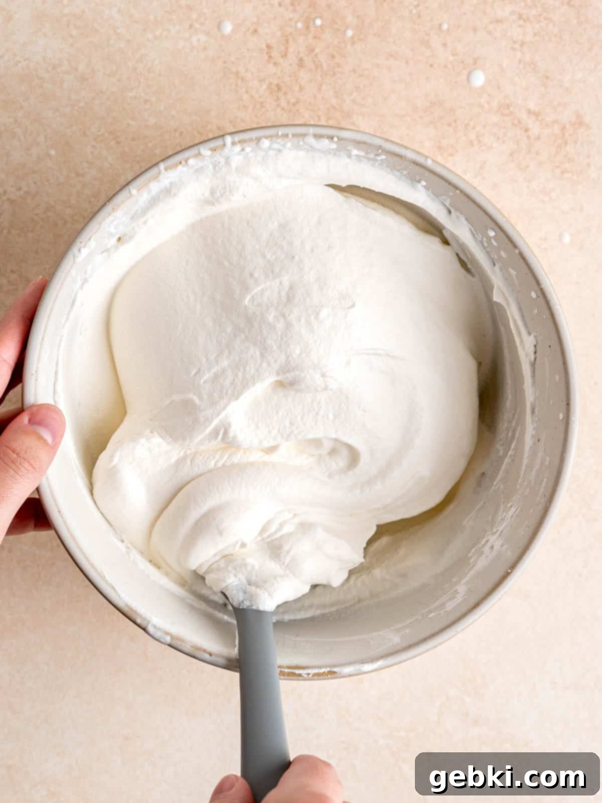 Effortless Honey Vanilla Delight 8 Homemade whipped cream in a clear glass bowl, showing its thick and airy texture.