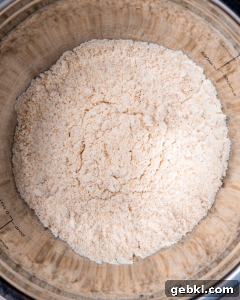 Close-up of meringue reaching soft peaks in a stand mixer.