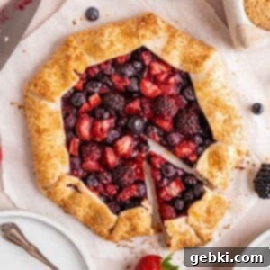 A mixed berry galette with a slice cut out, revealing the vibrant fruit filling.