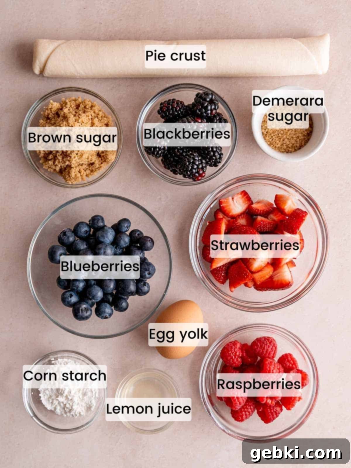 Ingredients needed to make a galette with mixed berries, including fresh berries, pie crust, sugar, lemon juice, and corn starch.